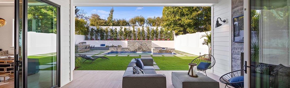 View of a RODCO custom built home backyard overlooking a pool and patio furniture